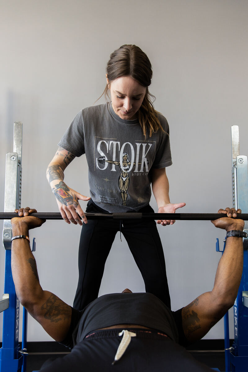 Sammi coaching a client on the bench press