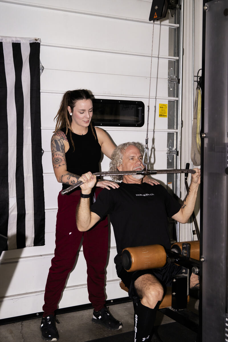 Sammi coaching a client through a lat pulldown